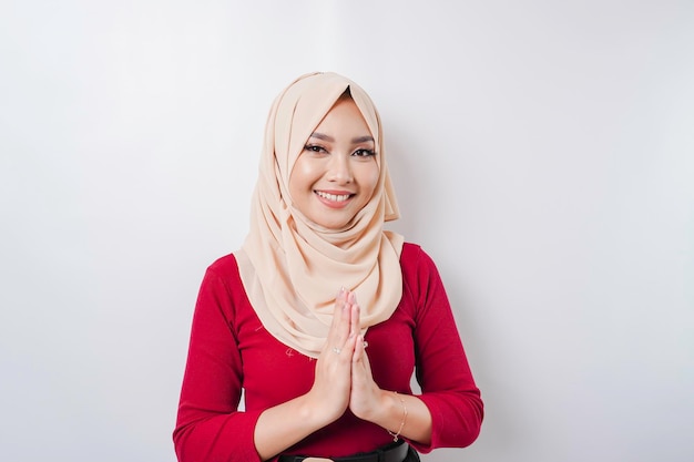 Retrato de una joven y hermosa mujer musulmana que usa un hiyab haciendo un gesto de saludo de Eid Mubarak