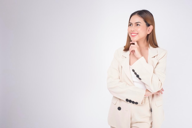 Retrato de una joven y hermosa mujer de negocios con traje en un estudio de fondo blanco.