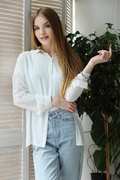 Retrato de una joven hermosa mujer posando en un estudio fotográfico cerca de una ventana