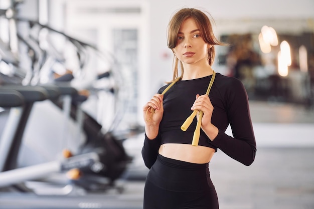 Retrato de una joven y hermosa mujer con ropa deportiva que tiene un día de fitness en el gimnasio Sosteniendo una cuerda para saltar