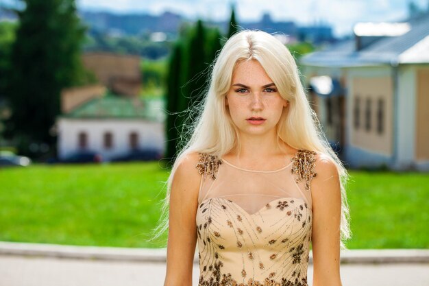 Retrato de una joven y hermosa mujer rubia en vestido beige