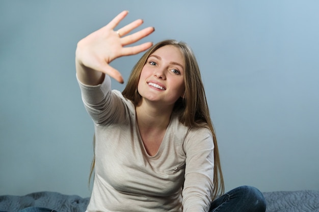 Retrato de joven hermosa mujer sonriente positiva agitando su brazo