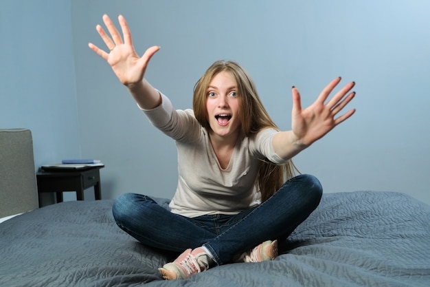 Retrato de joven hermosa mujer sonriente positiva agitando sus brazos y gesticulando con las manos hola, hola, adiós