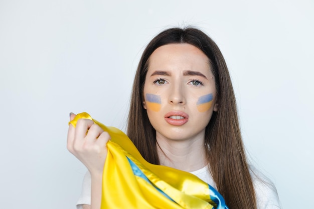 Retrato de joven hermosa mujer con soporte de bandera ucraniana sobre fondo blanco Detener la guerra en Ucrania