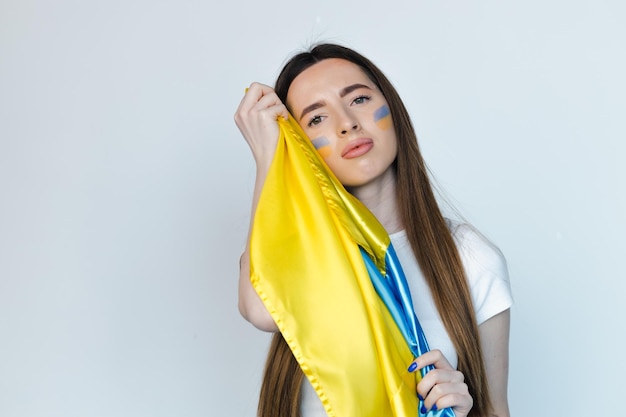 Retrato de joven hermosa mujer con soporte de bandera ucraniana sobre fondo blanco Detener la guerra en Ucrania