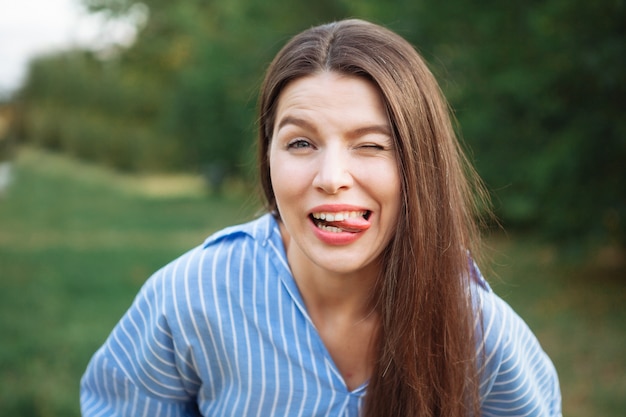 Retrato de joven hermosa niña sonriente. Mujer haciendo fotos en la calle.