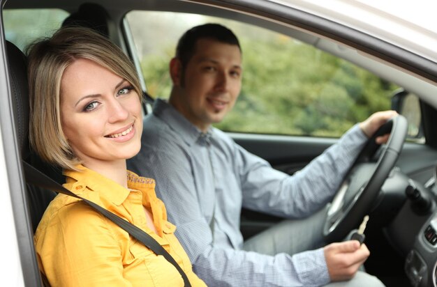 Retrato de joven hermosa pareja sentada en el coche