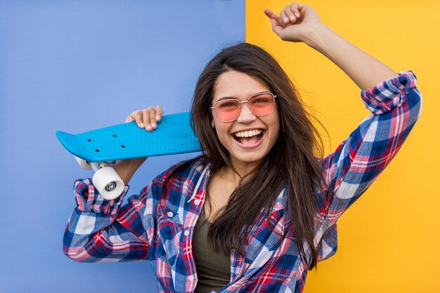 Retrato de joven hermosa con patineta