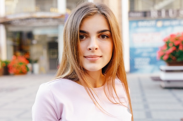 Retrato de joven hermosa posando en la calle