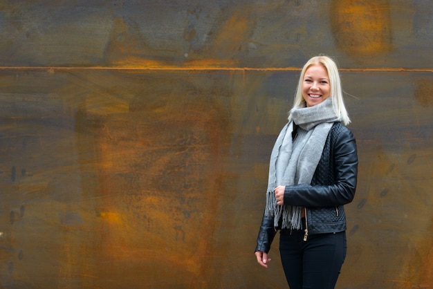 Retrato de joven hermosa rubia escandinava contra la pared de metal oxidado al aire libre