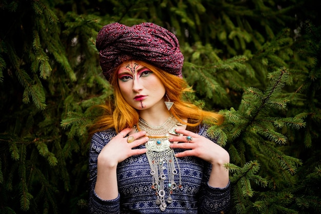 Retrato de una joven hermosa en un turbante en el jardín de otoño