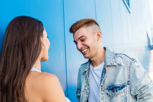 Retrato de un joven hermoso aislado riendo a su novia en azul