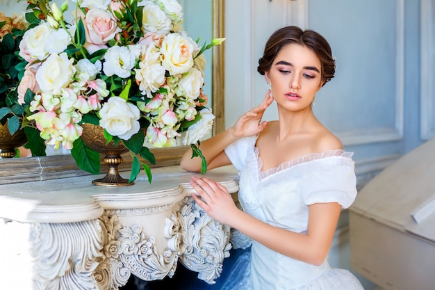 Retrato de una joven en un hermoso vestido en el interior, belleza femenina