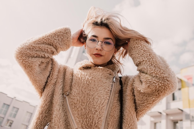 Retrato de una joven hipster con gafas y mirando a la cámara