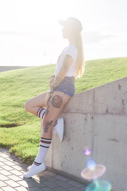 Retrato de una joven hipster sonriendo con un longboard al atardecer.