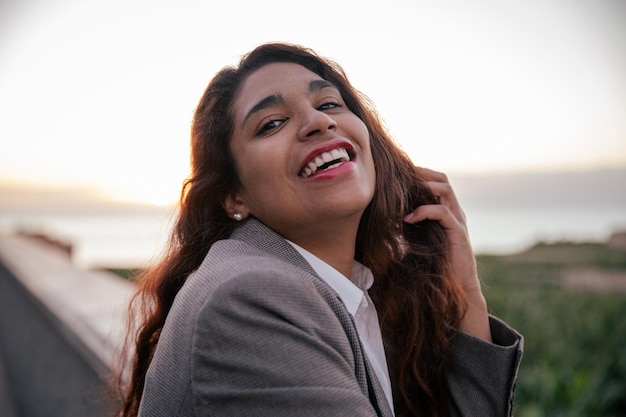 retrato, de, un, joven, hispano, mujer de negocios, sonriente, durante, ocaso