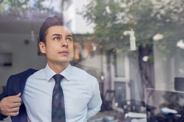 retrato, de, joven, hombre de negocios, atrás, cristal, en, oficina, poner, en, el suyo, chaqueta