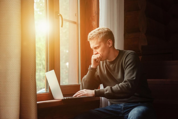 retrato, de, joven, hombre de negocios, con, computador portatil, en, ventana, de, sala