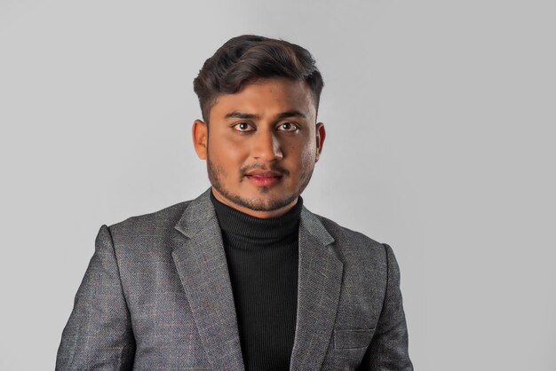 Retrato de un joven hombre de negocios indio feliz con una chaqueta de fondo gris posando satisfecho y exitoso hombre con traje formal