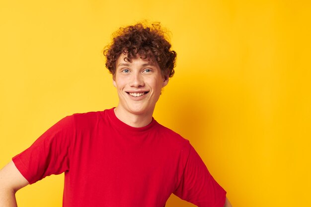 Retrato de un joven hombre rizado camiseta roja diversión posando ropa casual fondo aislado inalterado