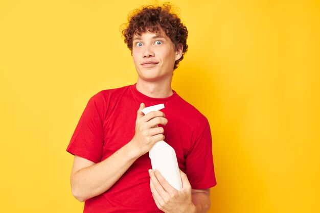 Retrato de un joven hombre rizado detergentes cuidado en el hogar posando fondo aislado inalterado