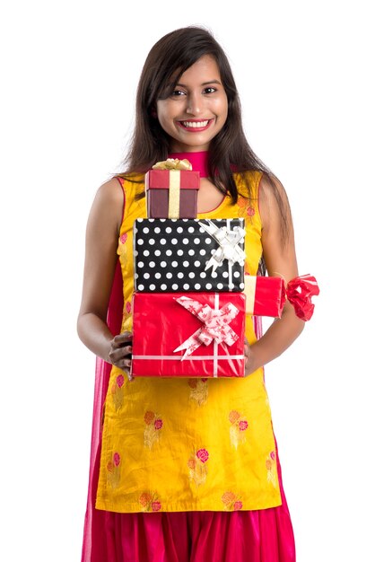 Retrato de joven India sonriente feliz con cajas de regalo sobre un fondo blanco.