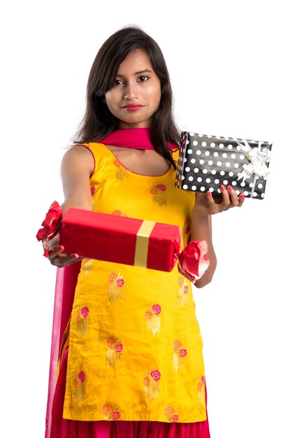 Retrato de joven India sonriente feliz con cajas de regalo sobre un fondo blanco.