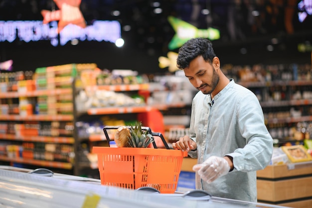 Retrato de un joven indio guapo de pie en una tienda de comestibles o un supermercado Closeup enfoque selectivo