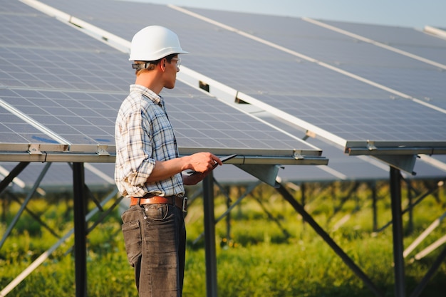 El retrato de un joven ingeniero comprueba los paneles solares fotovoltaicos