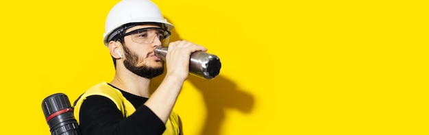 Retrato de joven ingeniero hombre vestido con casco de seguridad, gafas y chaqueta