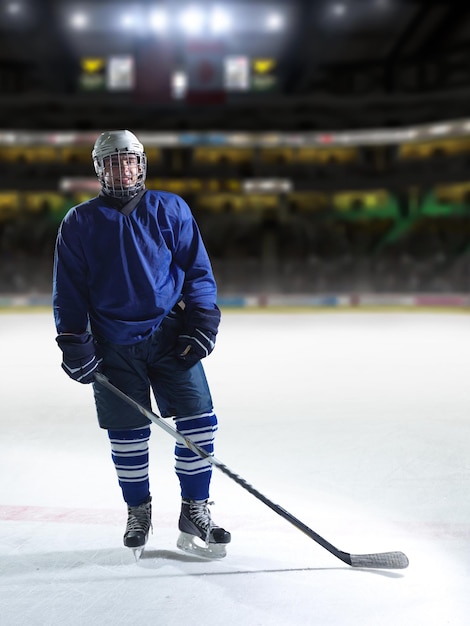 Retrato de joven jugador de hockey sobre hielo en formación en fondo negro