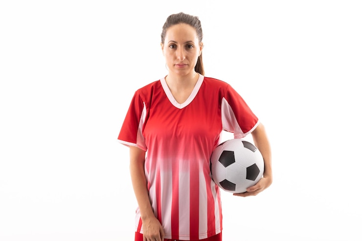 Foto retrato de una joven jugadora caucásica confiada con una pelota de fútbol contra un fondo blanco