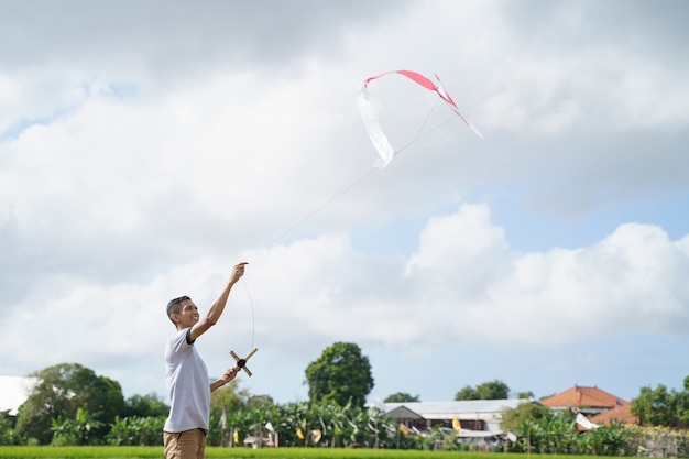 Retrato de un joven jugando una cometa en un campo de arroz