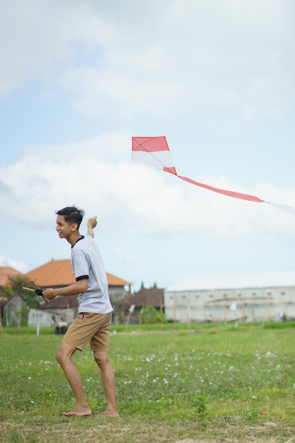 Retrato joven jugando cometa en el campo