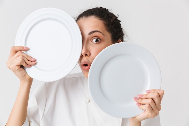 Retrato de una joven juguetona lavando platos