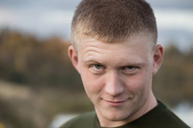 Retrato de un joven en un lago en otoño