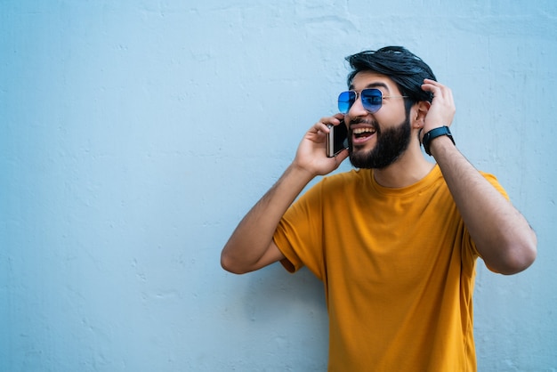 Retrato de joven latino hablando por teléfono. Concepto de comunicación.