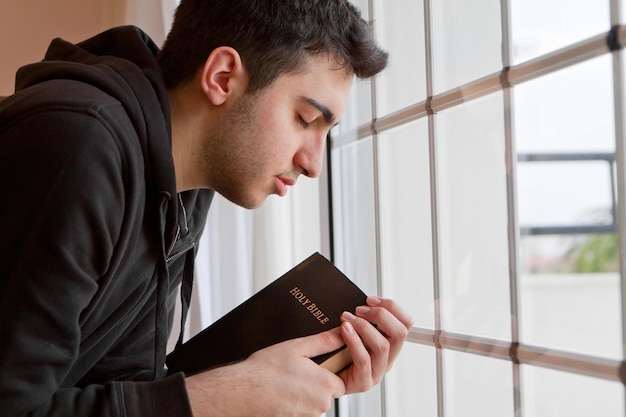 Foto retrato de un joven con un libro en la mano