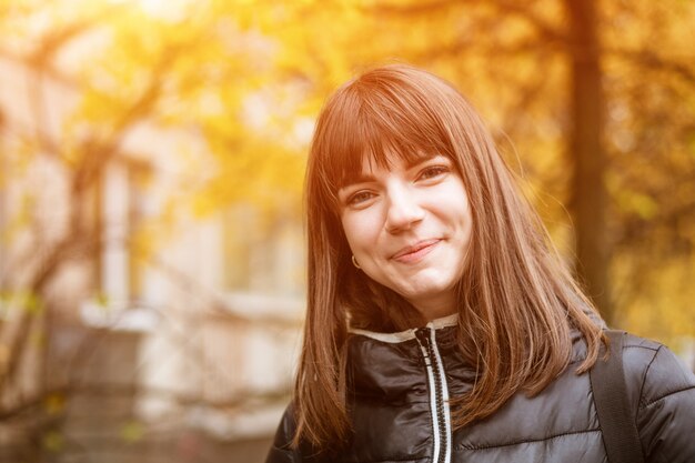 Retrato de una joven linda en otoño en un día soleado