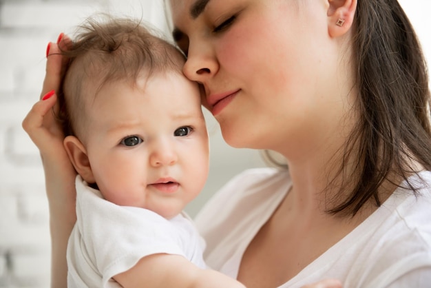 Foto retrato de una joven madre con un bebé en brazos