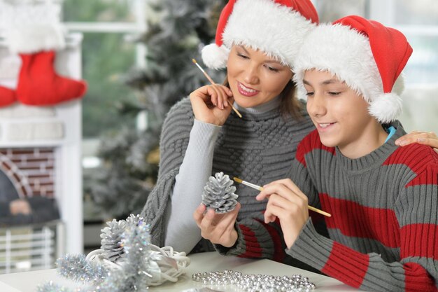 Retrato de joven madre con hijo preparándose para la Navidad