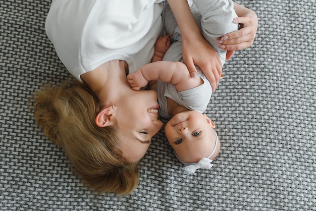 Retrato de joven madre con lindo bebé en casa