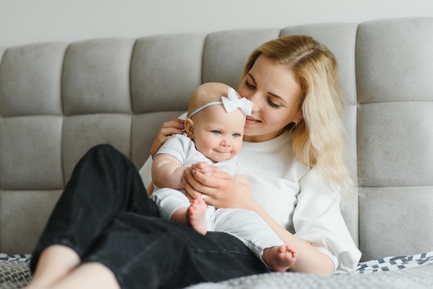 Retrato de joven madre con lindo bebé en casa