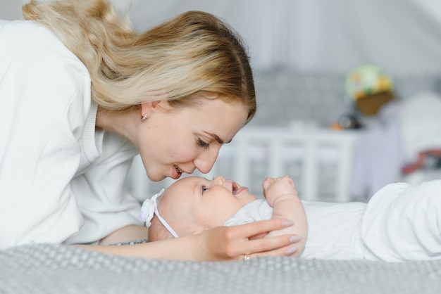 Retrato de joven madre con lindo bebé en casa