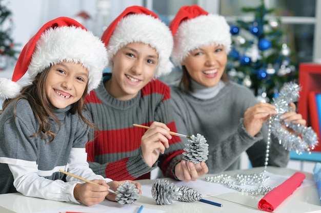 Retrato de joven madre con niños preparándose para la Navidad