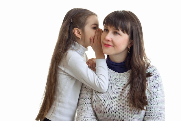 El retrato de una joven madre y su hija que pone los secretos en el ojal está aislado en un primer plano de fondo blanco