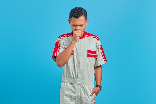 Retrato de joven mecánico asiático que se siente mal y la tos es un síntoma de resfriado o bronquitis