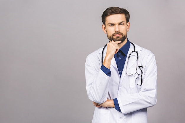 Retrato de joven médico serio con estetoscopio sobre el cuello en bata médica