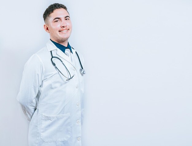 Foto retrato de un joven médico sonriente aislado retrata de un médico latino aislado con espacio para copiar