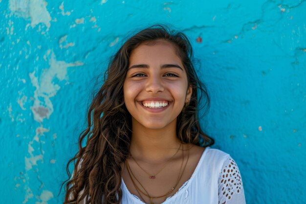 Retrato de una joven mexicana sonriendo contra una pared azul
